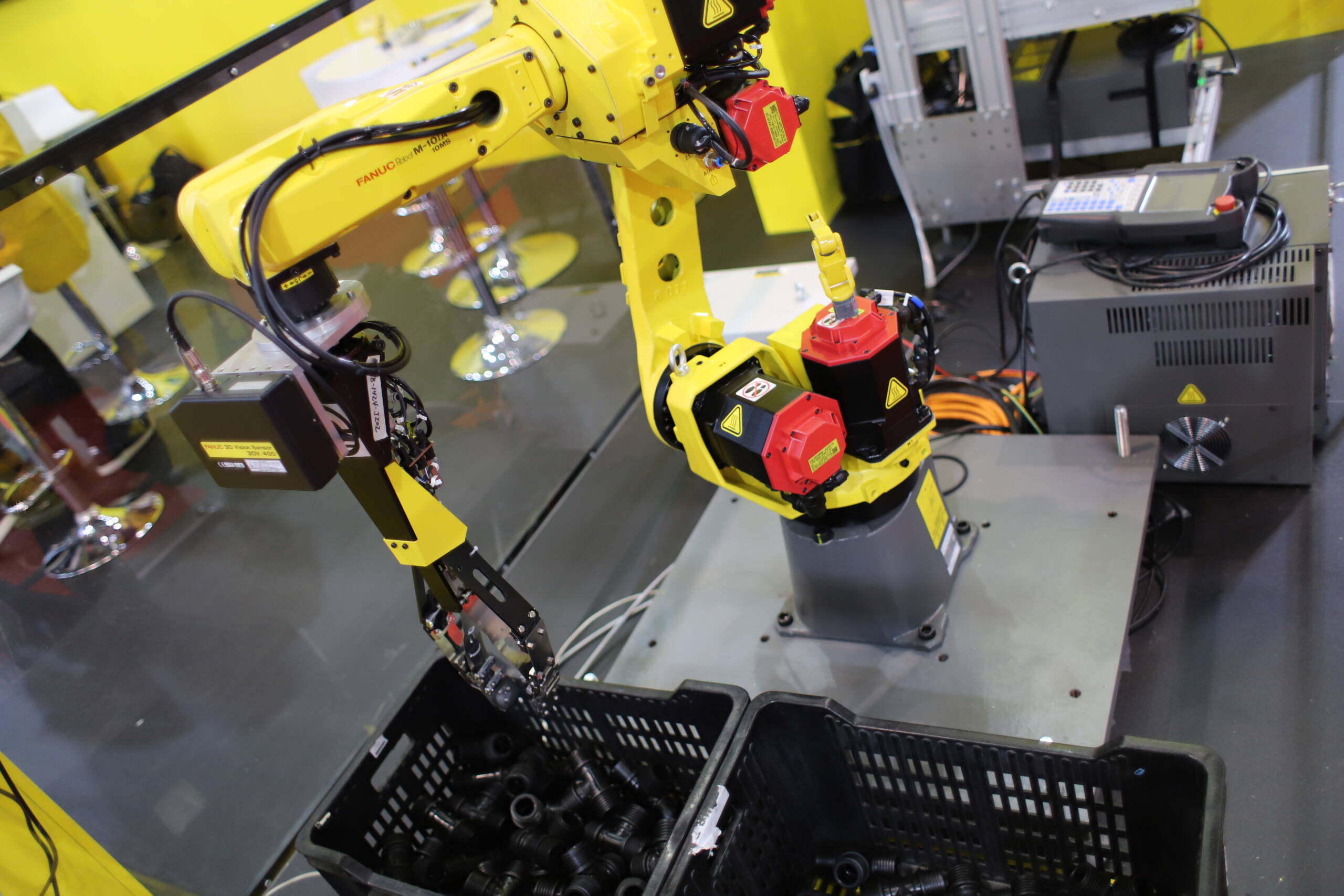 A FANUC M-10iA robot arm equipped with a 3D vision system performing unstructured bin-picking — one of the more demanding real-world manipulation tasks in industrial automation. No legs, no balance system, no humanoid architecture. The task defined the form.